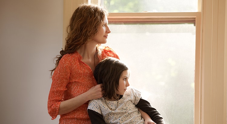 Mother and daughter looking through window. Is now a good time to sell a home?